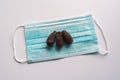 Dates or kurma with medical mask on white background