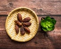 Dates or kurma on a wooden table with flower pot Royalty Free Stock Photo