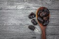 Dates in spoon wood on wooden floor background.