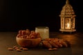Dates in wooden bowl, milk and lantern on stone table. Muslim holy month Ramadan Kareem. Copy space