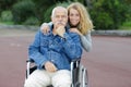 Daughte and father in wheelchair outdoors