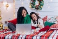 Daughter and black mother communicate using laptop on bed Royalty Free Stock Photo