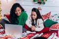 Daughter and black mother communicate using laptop on bed Royalty Free Stock Photo