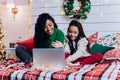 Daughter and black mother communicate using laptop on bed Royalty Free Stock Photo