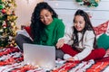 Daughter and black mother communicate using laptop on bed Royalty Free Stock Photo