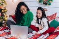 Daughter and black mother communicate using laptop on bed Royalty Free Stock Photo