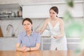 Daughter calms down her mother after a domestic quarrel in kitchen