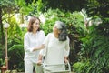 Daughter caring for elderly Asian mother Come take a walk in the garden with fresh green plants.