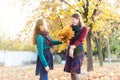 The daughter congratulates her mother and gives her an autumn bouquet of yellow leaves