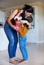 Daughter embracing her mother after giving her flowers on her birthday, full length, vertical Royalty Free Stock Photo