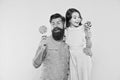 Daughter and father eat sweet candy. Bearded man and cute sweet baby. Loving daddy and small girl eating lollipop