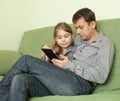 Daughter and father using e-book