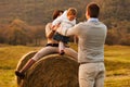 daughter finds joy on a hay bale, surrounded by unyielding love of her parents Royalty Free Stock Photo