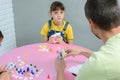 Daughter funny looks at dad, playing a board game at the table