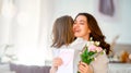 Daughter giving mother bouquet of flowers Royalty Free Stock Photo