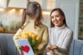 Daughter giving mother bouquet of flowers Royalty Free Stock Photo