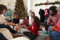 Daughter Giving Mother Gift As Multi Generation Family Celebrate Christmas At Home Together