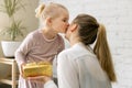 daughter giving present and kiss to her mom at home. birthday, womens day or mothers day concept Royalty Free Stock Photo