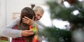 Daughter giving present to happy mother and embrace indoors at home at Christmas Royalty Free Stock Photo