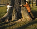Daughter and granny embrace giant tree Royalty Free Stock Photo
