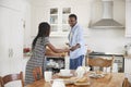 Daughter Helping Father To Clear Table After Family Meal