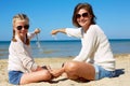 Daughter and her mom playing with sand on the beach. Royalty Free Stock Photo