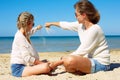 Daughter and her mom playing with sand on the beach.  together Royalty Free Stock Photo