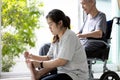 Daughter hold a nail clipper,cutting the ingrown nail for disabled senior mother in wheelchair,asian woman help to cut the toe