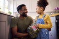 Daughter Holding Cap Of American Army Father In Uniform Home On Leave In Family Kitchen Royalty Free Stock Photo