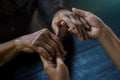 The daughter holding hand and takes care mother elderly that is alzheimer and parkinson`s patient on dark background