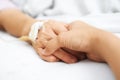 Daughter holding her mother hand in hospital