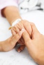 Daughter holding her mother hand in hospital