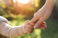 Daughter holding mother`s hand outdoors, closeup view Royalty Free Stock Photo