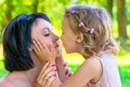 Daughter holds the face of his mother and kisses