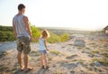Daughter holds father`s hand on a high mountain at sunset. Family travel, Walking, support, Father`s Day