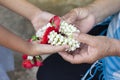 Daughter holds a garland to pay her mother with love and respect on Mother`s Day in Thailand or the Songkran festival.