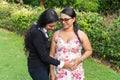 A daughter holds her mother`s hands on her pregnant belly