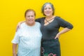 Daughter hugging her mother on a plane yellow background Royalty Free Stock Photo