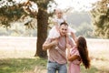 The daughter hugging parents on nature. Mom, dad and girl toddler, walk in the park. Happy young family spending time Royalty Free Stock Photo