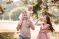 The daughter hugging parents on nature. Mom, dad and girl toddler, walk in the park. Happy young family spending time Royalty Free Stock Photo