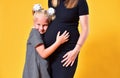 Daughter hugs the belly of her pregnant mother Royalty Free Stock Photo