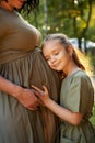 The daughter hugs the pregnant mother and waits for the appearance of her sister Royalty Free Stock Photo