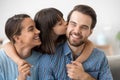 Daughter kissing father sitting together on sofa