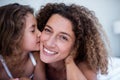 Daughter kissing her mother on the cheek Royalty Free Stock Photo