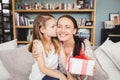 Daughter kissing mother with gift box Royalty Free Stock Photo