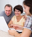 Daughter learning parents searching documents on laptop