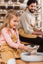 daughter making ceramic pot on pottery wheel with father Royalty Free Stock Photo