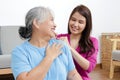 Daughter massaging shoulder for elderly Asian mother with shoulder pain. Royalty Free Stock Photo