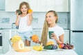 Daughter and mother drinks green smoothie and eating fruits. Vegan meal and detox menu. Mother and daughter drinking