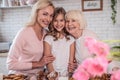 Daughter, mother and grandmother cooking on kitchen. Women generation baking together.